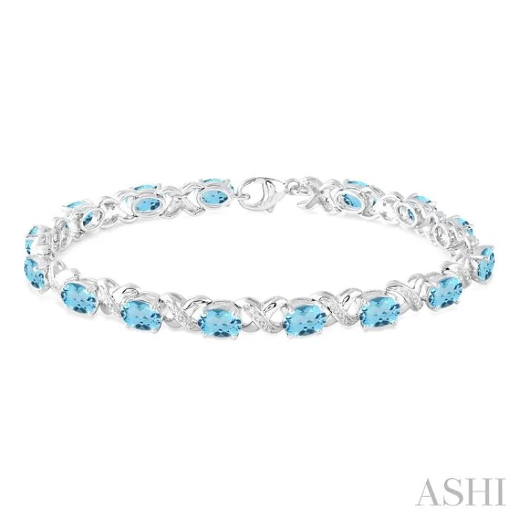 Ladies bracelets chain designs-7x5 mm Oval Cut Blue Topaz and 1/20 Ctw Round Cut Diamond Fashion Bracelet in Sterling Silver